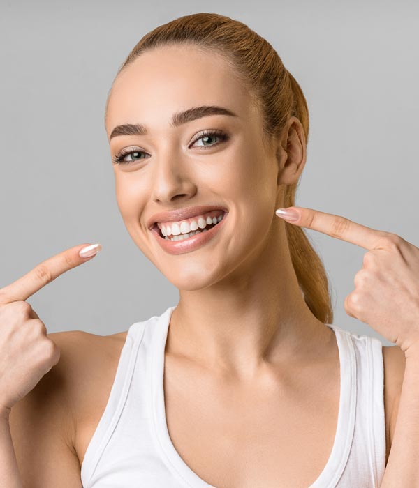 person smiling and pointing at face